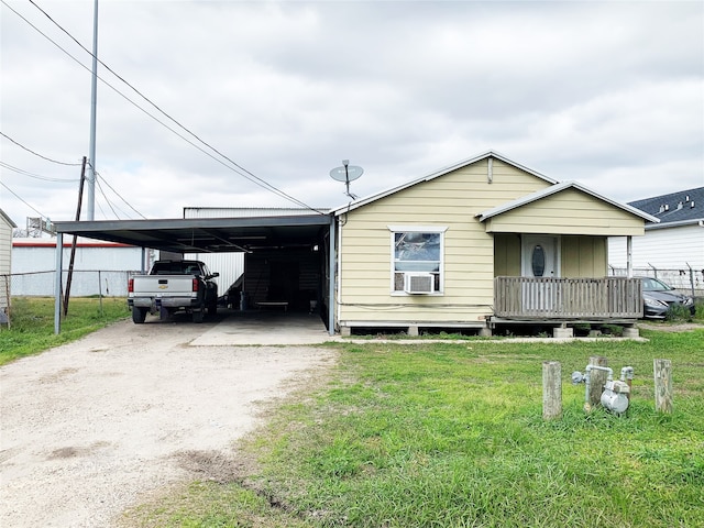 view of front of house featuring cooling unit, a wooden deck, a carport, and a front yard