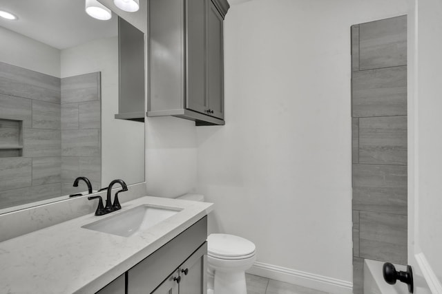 bathroom featuring tile patterned flooring, vanity, and toilet