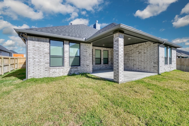 back of property featuring a lawn and a patio area