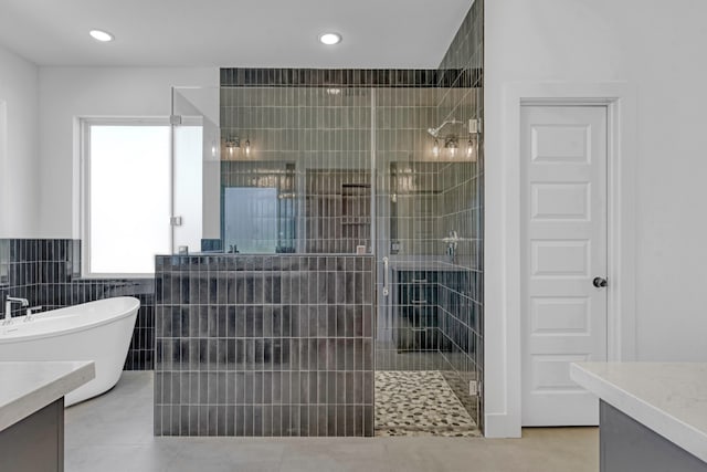 bathroom with vanity, shower with separate bathtub, tile walls, and tile patterned floors