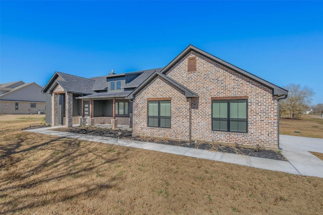 view of front of home with covered porch and a front lawn