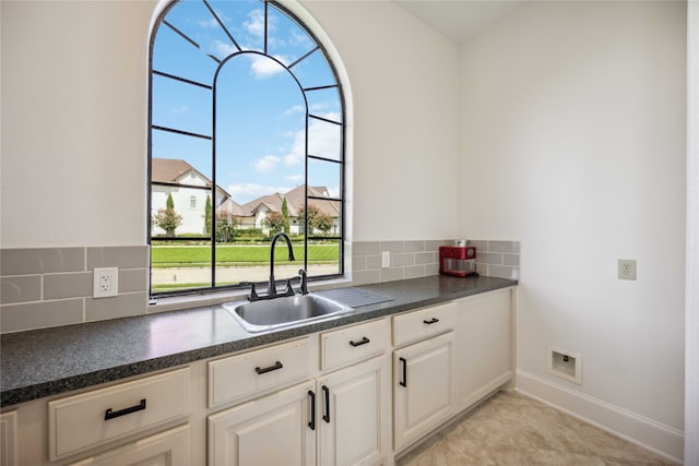 kitchen with white cabinetry, light tile patterned floors, tasteful backsplash, and sink