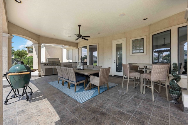 view of patio / terrace with exterior kitchen, a grill, and ceiling fan