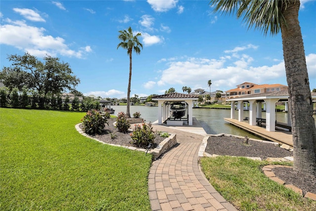 view of dock with a lawn and a water view