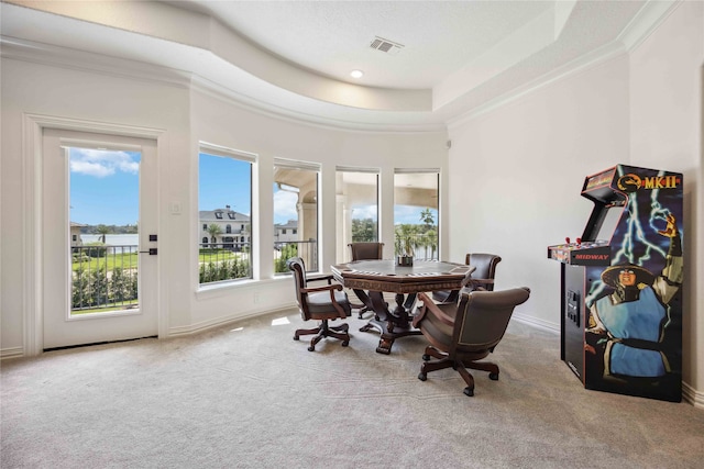 carpeted dining room with crown molding and a tray ceiling