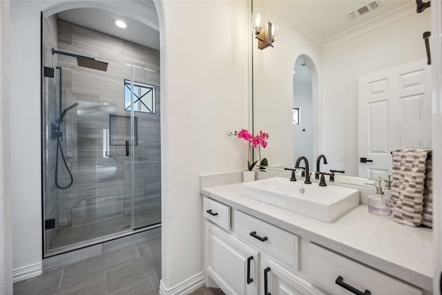 bathroom with walk in shower, crown molding, and vanity