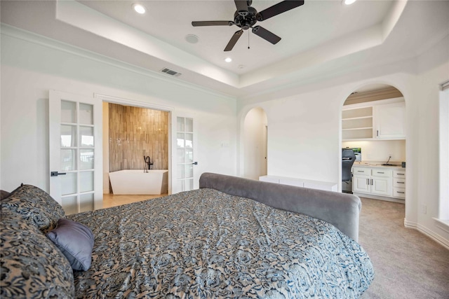 bedroom with crown molding, a raised ceiling, ceiling fan, and light colored carpet