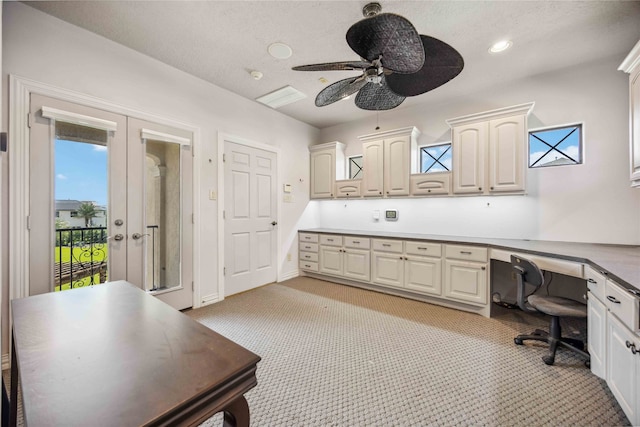 home office with built in desk, a healthy amount of sunlight, and ceiling fan