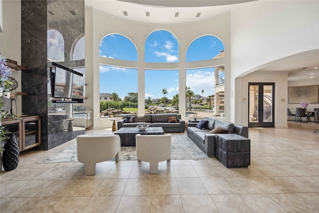 living room featuring ornamental molding, a towering ceiling, and french doors