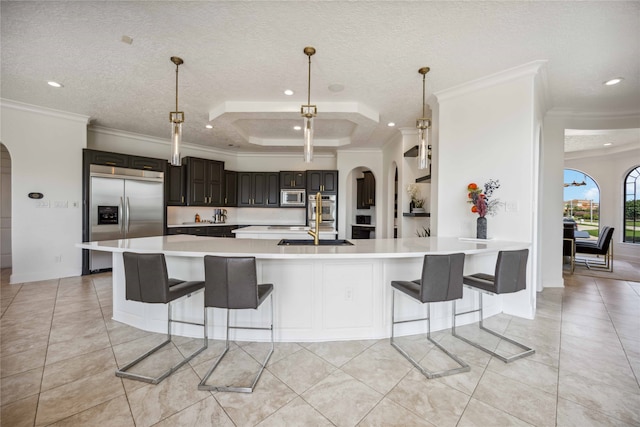 kitchen featuring built in appliances, ornamental molding, dark brown cabinetry, and a textured ceiling