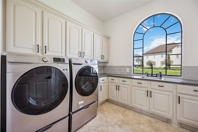 washroom featuring cabinets, separate washer and dryer, light tile patterned floors, and sink