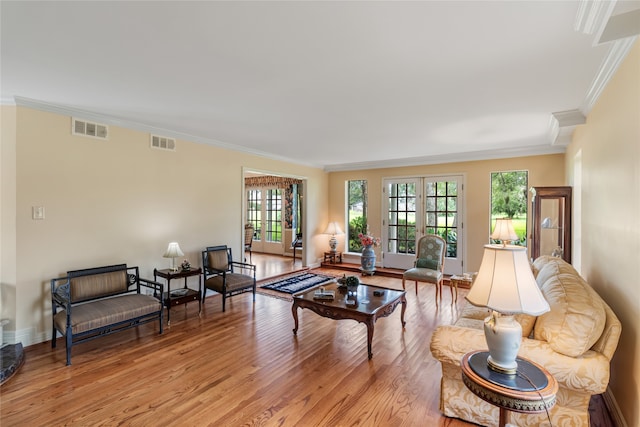 living room with crown molding and light hardwood / wood-style floors