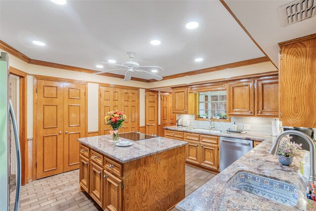 kitchen featuring a kitchen island, light stone countertops, tasteful backsplash, stainless steel appliances, and ceiling fan