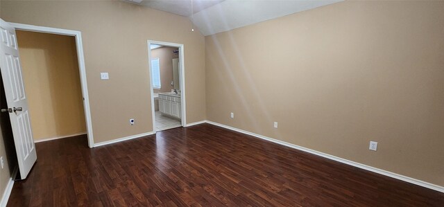 unfurnished bedroom featuring dark hardwood / wood-style floors and vaulted ceiling