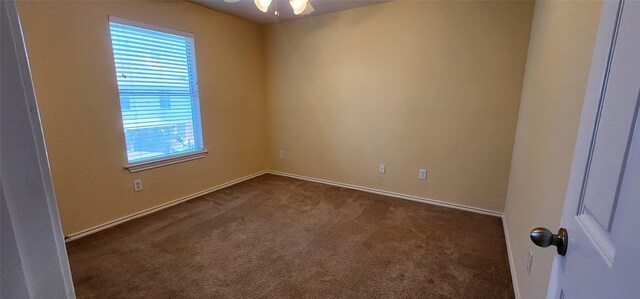 unfurnished room with ceiling fan and dark colored carpet