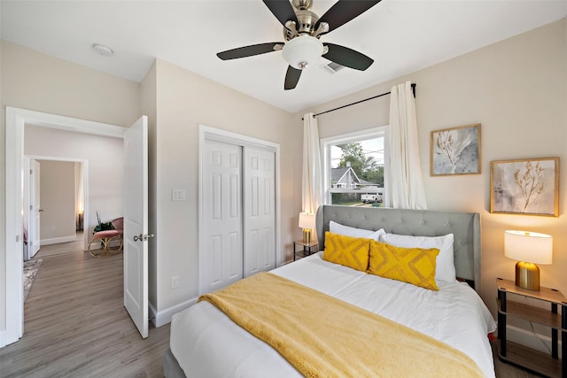 bedroom featuring ceiling fan, wood-type flooring, and a closet