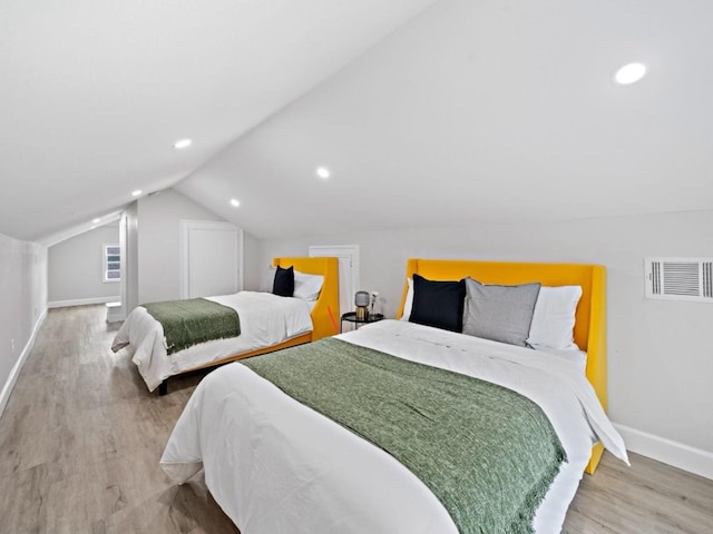 bedroom with vaulted ceiling and hardwood / wood-style floors