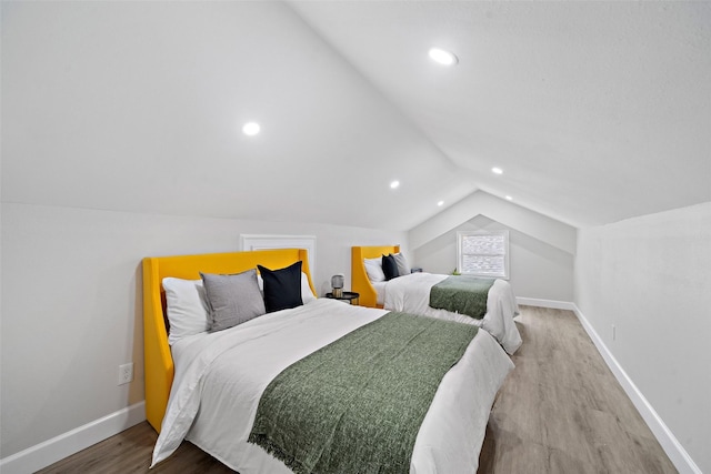 bedroom with wood-type flooring and vaulted ceiling