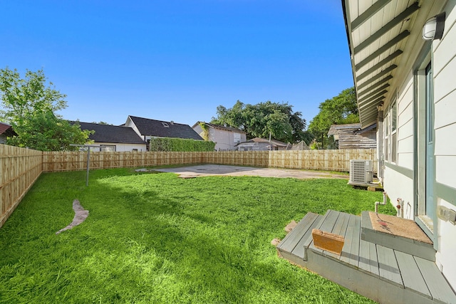 view of yard with central AC and a patio area