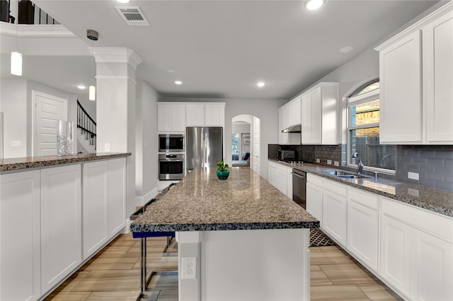 kitchen featuring dark stone counters, sink, stainless steel appliances, and white cabinets