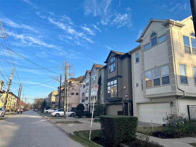 view of street featuring sidewalks, a residential view, and traffic signs