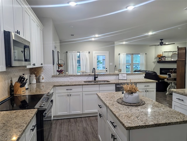 kitchen featuring a kitchen island, stainless steel appliances, sink, and white cabinets