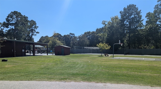 view of yard with a storage unit and basketball hoop