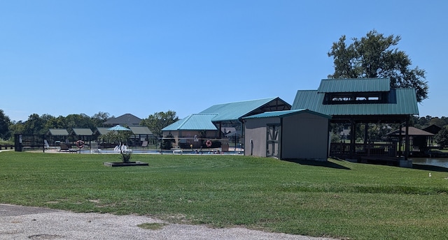 surrounding community with a swimming pool, a yard, and a shed