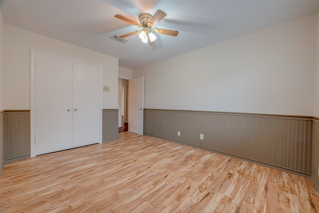 unfurnished room with light wood-type flooring and ceiling fan