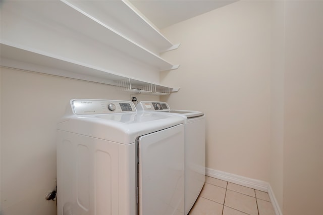 laundry area featuring washer and clothes dryer and light tile patterned floors