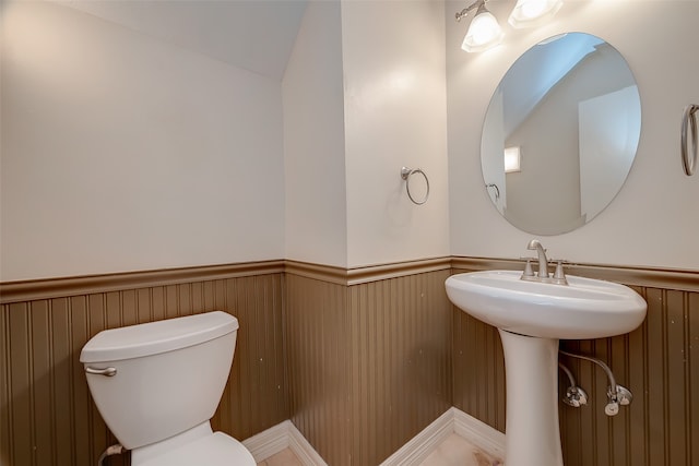 bathroom featuring lofted ceiling and toilet