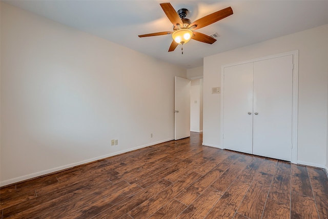 unfurnished bedroom featuring a closet, ceiling fan, and dark wood-type flooring