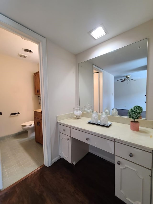 bathroom featuring ceiling fan, vanity, hardwood / wood-style floors, and toilet