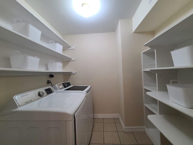 laundry room with independent washer and dryer and light tile patterned flooring