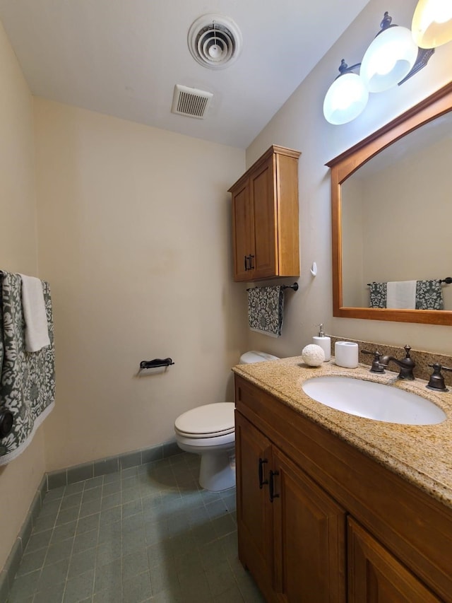 bathroom with tile patterned flooring, vanity, and toilet