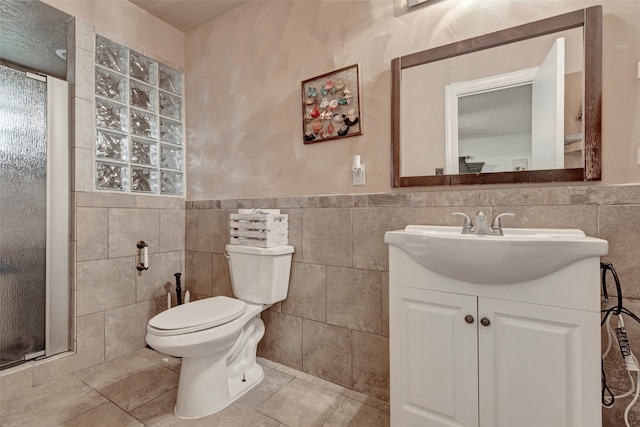 bathroom with toilet, walk in shower, vanity, tasteful backsplash, and tile walls