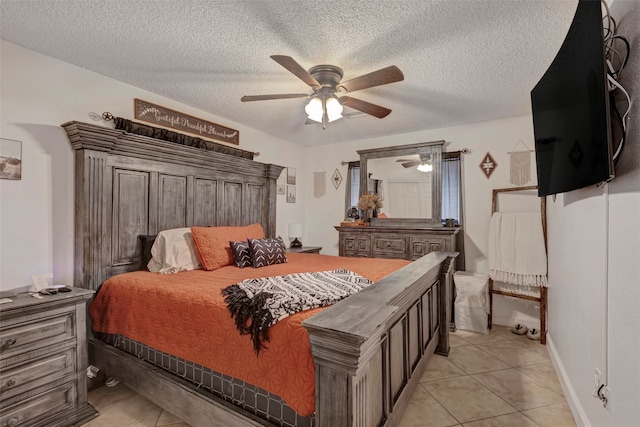 tiled bedroom with ceiling fan and a textured ceiling