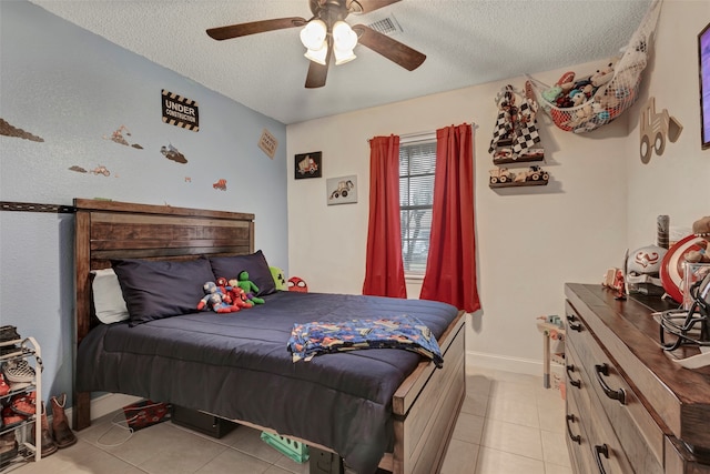 bedroom featuring a textured ceiling, light tile patterned floors, and ceiling fan