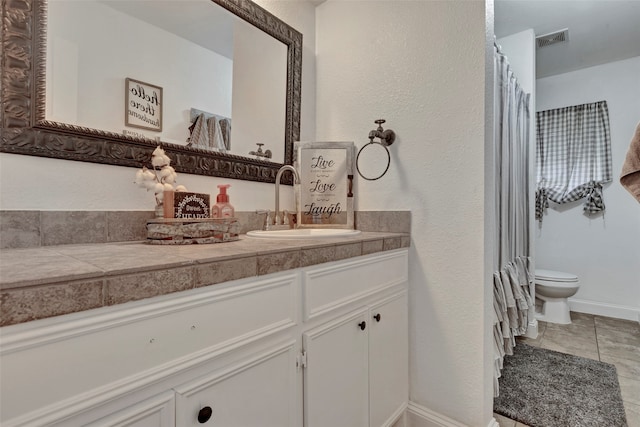 bathroom featuring tile patterned floors, toilet, and vanity