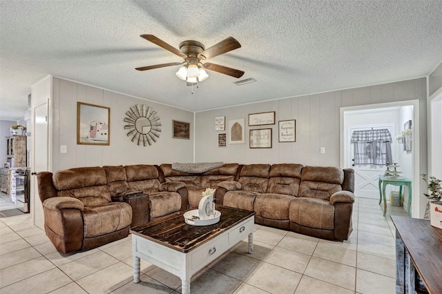 tiled living room featuring ceiling fan and a textured ceiling