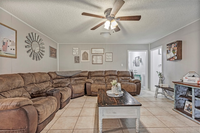 living room with ceiling fan, light tile patterned flooring, and a textured ceiling