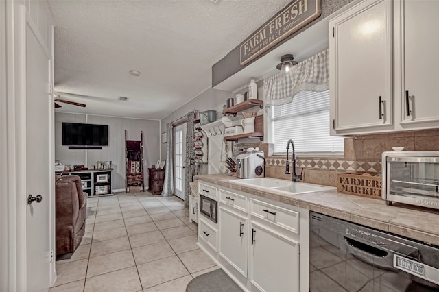 kitchen with dishwasher, tile countertops, sink, ceiling fan, and white cabinets