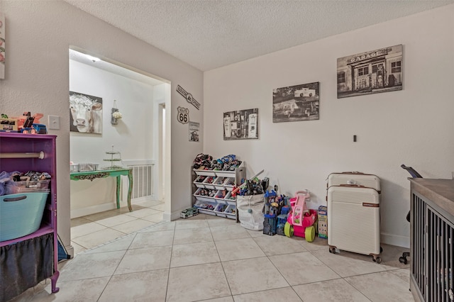 interior space with a textured ceiling and light tile patterned flooring