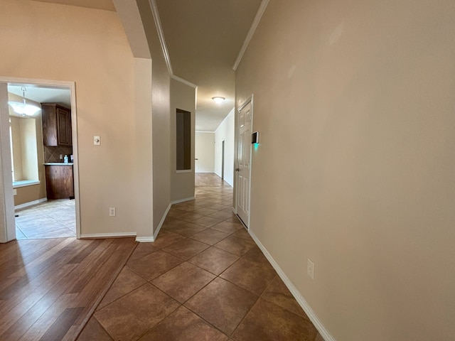 corridor with ornamental molding and hardwood / wood-style flooring