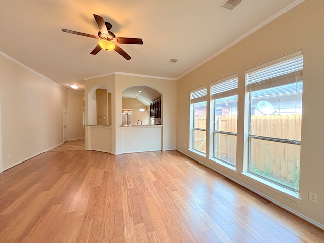 unfurnished living room with lofted ceiling, ceiling fan, ornamental molding, and light wood-type flooring