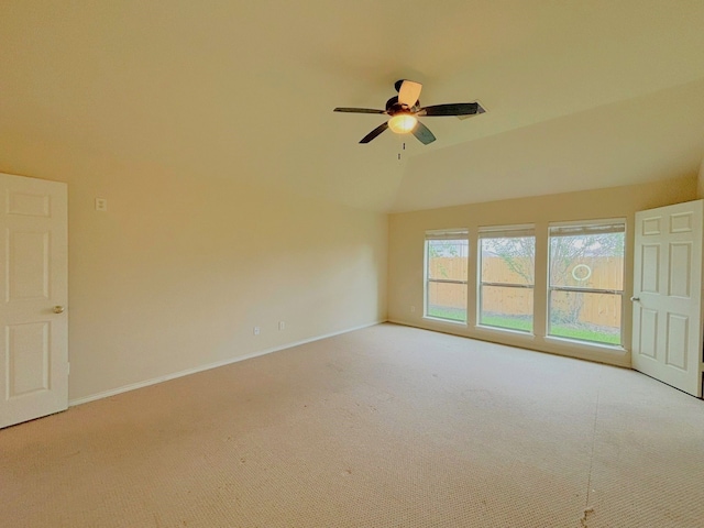 empty room featuring ceiling fan, light colored carpet, and vaulted ceiling