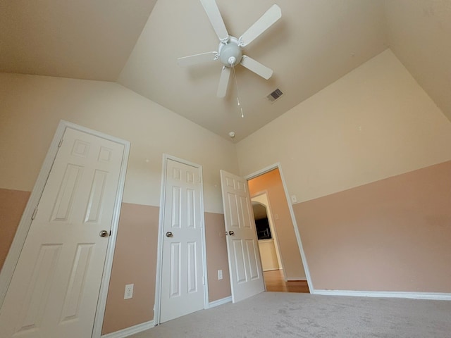 unfurnished bedroom with light colored carpet, lofted ceiling, and ceiling fan