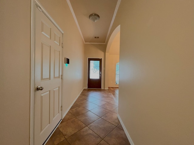 hall featuring light tile patterned floors and crown molding