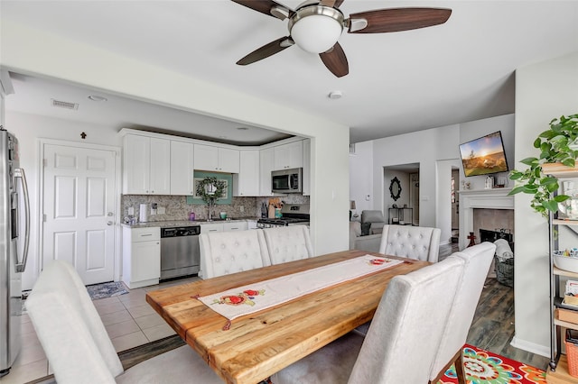 dining room featuring ceiling fan and sink