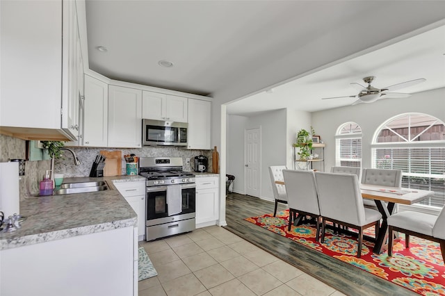 kitchen featuring tasteful backsplash, white cabinetry, sink, and appliances with stainless steel finishes